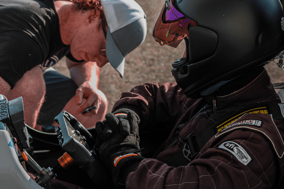 Webber sits in the car while Payton checks a part Webber sits in the car while Payton checks a part