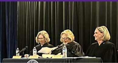 Three Justices sit at a table during a court hearing.