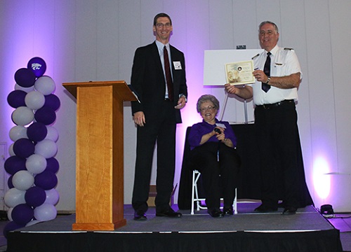Jerald Eichelberger, left, manager of the Wichita Flight Standards District Office, presents Bill Gross, right, aviation professor and chief flight instructor at the Kansas State University Polytechnic Campus, with the Wright Brothers Master Pilot Award. The award was part of an event honoring Gross' 50 years of flight. With Gross is his wife, Elaine. 