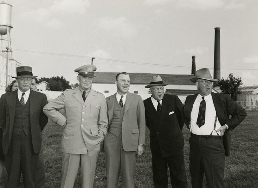 U.S. President Eisenhower with K-State President Milton Eisenhower (right of U.S. President Eisenhower) watching a football practice. Other individuals are unknown. 