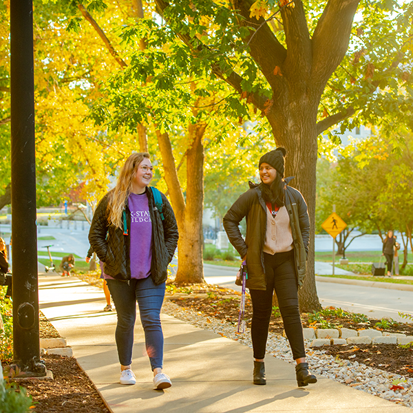 two students walking in fall