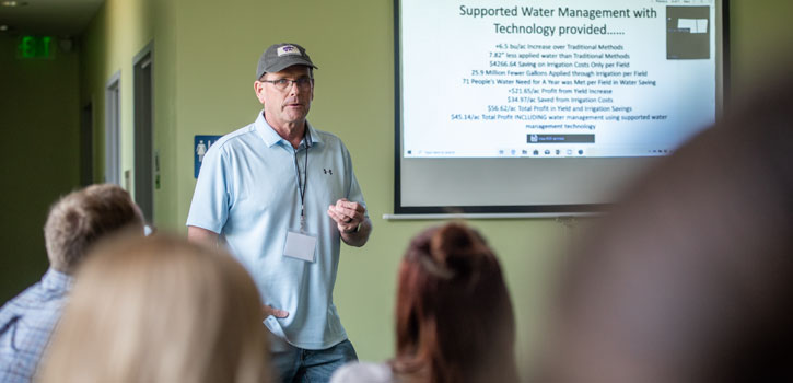 A farmer works with a K-State research team.