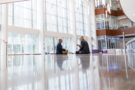 In this photo, Edward Nowlin and Doug Walker have a discussion in the College of Business Administration building. 