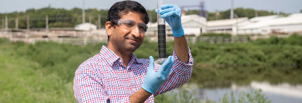 Prathap Parameswaran collects a wastewater sample for analysis