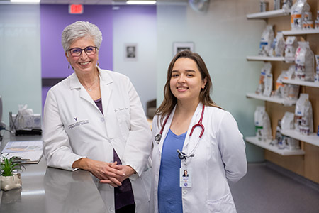 Susan Nelson, clinical professor, left, and Paulina Macias, intern veterinarian, work at the Hill’s Pet Health and Nutrition Center.