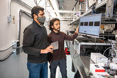 Anbu Venkatachalam, left, and Avijit Duley monitor the data recorded using an ion spectrometer.