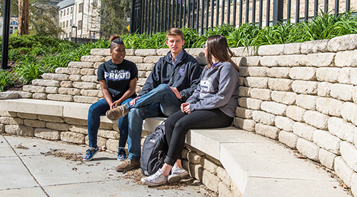 Students sitting on bench on campus