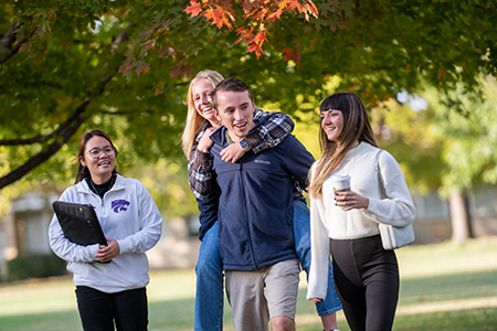 four students walking by Call hall