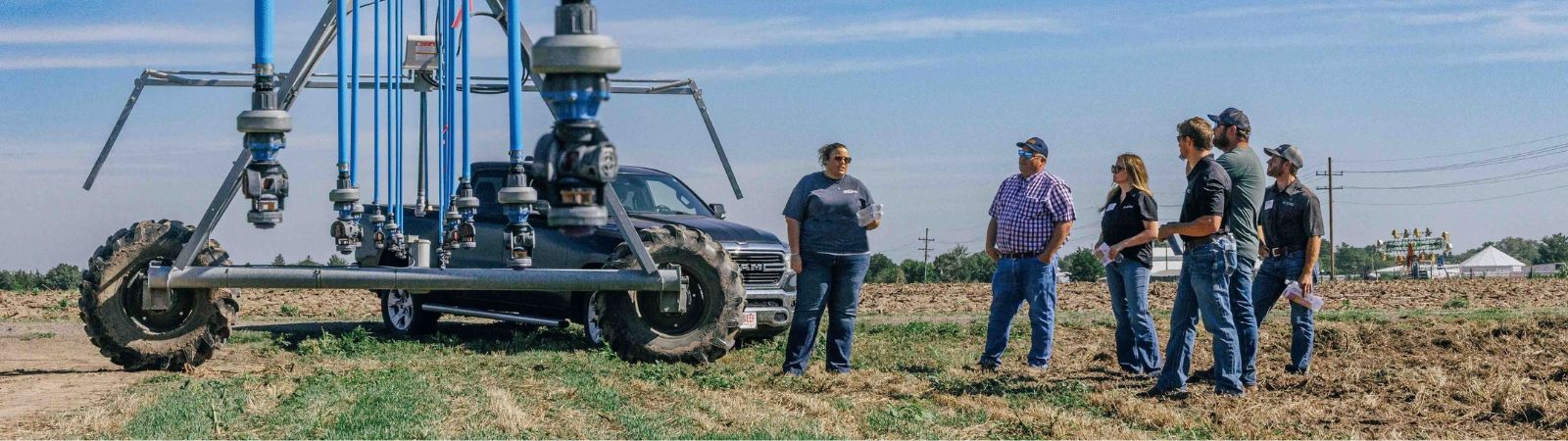 irrigation pivot photographed over young corn with a blue sky