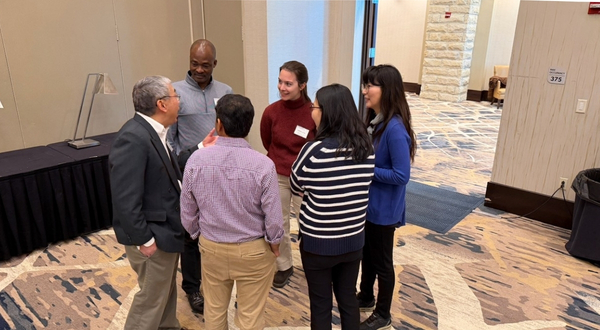 a group of six faculty form a small circle