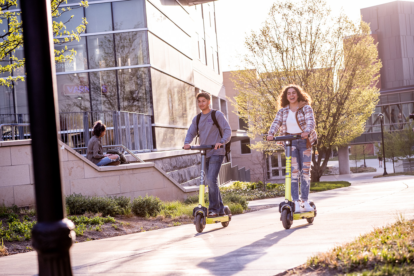 Students riding scooters on campus